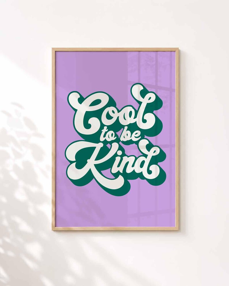 Puede incluir: Una l&aacute;mina enmarcada con fondo morado claro y el texto Cool to be Kind escrito en una fuente retro blanca y negrita. Las letras tienen una sombra paralela de color verde oscuro, creando un efecto de capas dentro de un marco de madera clara.