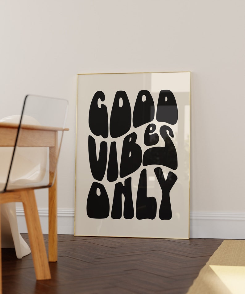 May include: A black and white poster with a gold frame. The poster has the text "GOOD VIBES ONLY" in a stylised font.