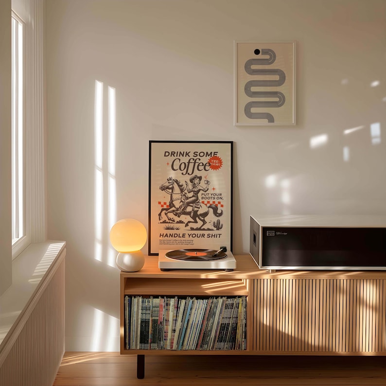 Cowgirl-inspired wall art print that says “Drink Some Coffee, Put Your Boots On, Handle Your Sh*t,” styled for a modern coffee bar or kitchen coffee station with a warm western vibe and motivational decor.