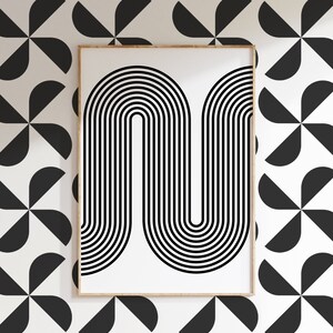 Puede incluir: Un p&oacute;ster enmarcado con una impresi&oacute;n abstracta en blanco y negro sobre un fondo blanco con un patr&oacute;n geom&eacute;trico de semic&iacute;rculos negros.