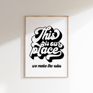 May include: Black and white typography print with the text "This is our place we make the rules" on a white background in a wooden frame.