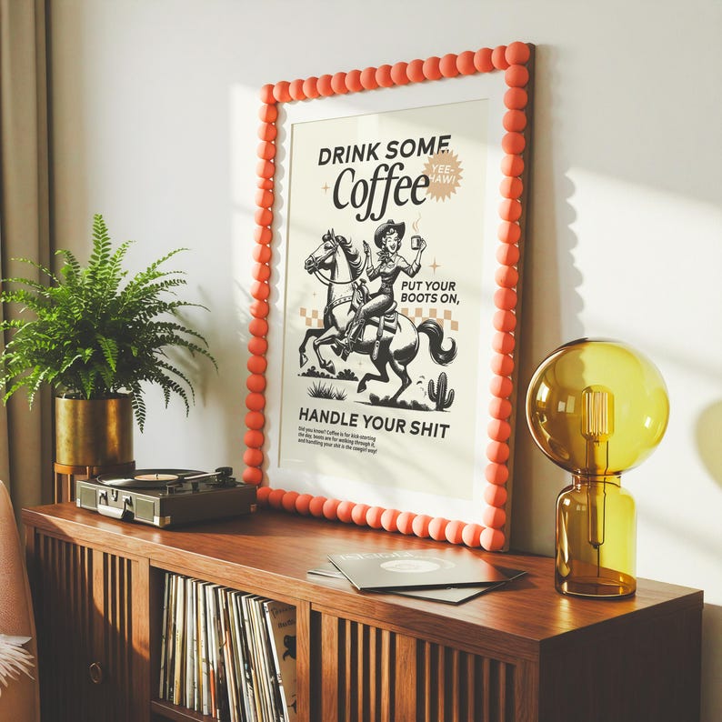 Cowgirl-inspired wall art print that says “Drink Some Coffee, Put Your Boots On, Handle Your Sh*t,” styled for a modern coffee bar or kitchen coffee station with a warm western vibe and motivational decor.