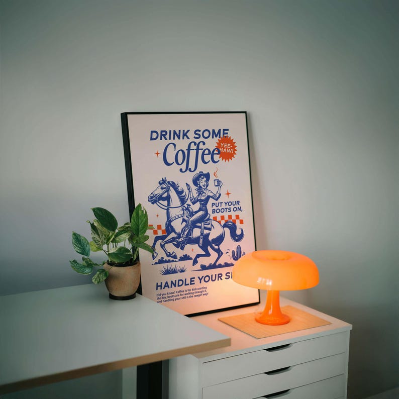 Cowgirl-inspired wall art print that says “Drink Some Coffee, Put Your Boots On, Handle Your Sh*t,” styled for a modern coffee bar or kitchen coffee station with a warm western vibe and motivational decor.