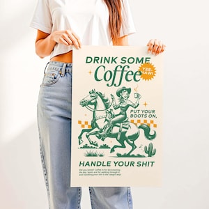 Cowgirl-inspired wall art print that says “Drink Some Coffee, Put Your Boots On, Handle Your Sh*t,” styled for a modern coffee bar or kitchen coffee station with a warm western vibe and motivational decor.