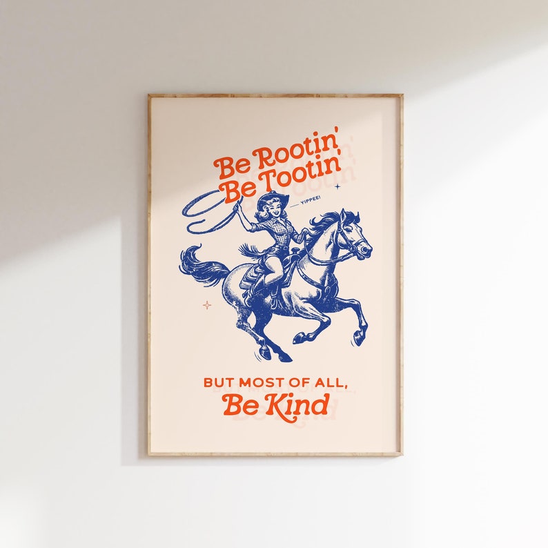 Pu&ograve; includere: Un poster in stile vintage con un'illustrazione blu di una donna a cavallo. Il testo sul poster recita "Be Rootin' Be Tootin' - YIPPEE! BUT MOST OF ALL, Be Kind."