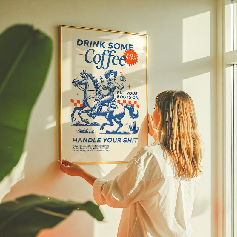 Cowgirl-inspired wall art print that says “Drink Some Coffee, Put Your Boots On, Handle Your Sh*t,” styled for a modern coffee bar or kitchen coffee station with a warm western vibe and motivational decor.