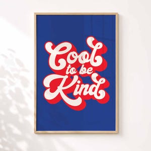 K&ouml;nnte beinhalten: Ein rechteckiges gerahmtes Wandbild mit tiefblauem Hintergrund und dem Text Cool to be Kind in einer fetten, wei&szlig;en Schrift im Retro-Stil. Die Buchstaben haben einen dicken roten Schlagschatten, der einen Schichteffekt innerhalb des hellen Holzrahmens erzeugt.