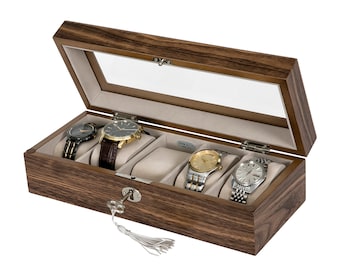 May include: A wooden watch box with a glass top and a key lock. The box has four compartments for storing watches. The box is made of dark wood with a wood grain pattern.