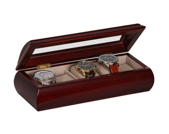 May include: A mahogany wood watch box with a glass top and four slots for watches. The box is open and three watches are visible.