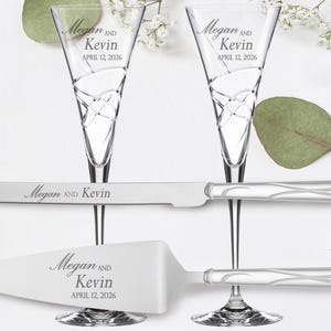 May include: A wedding cake cutting set with two champagne flutes and a cake knife. The flutes and knife are engraved with the names "Megan and Kevin" and the date "April 12, 2026".