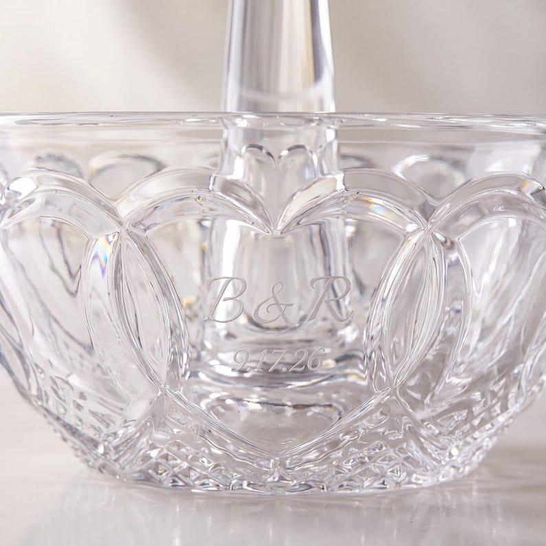 May include: A clear glass bowl featuring a central pillar and an intricate cut-glass pattern of interlocking heart shapes. The glass is engraved with the letters B&R and the date 9.17.26, showcasing a reflective surface and detailed geometric facets.