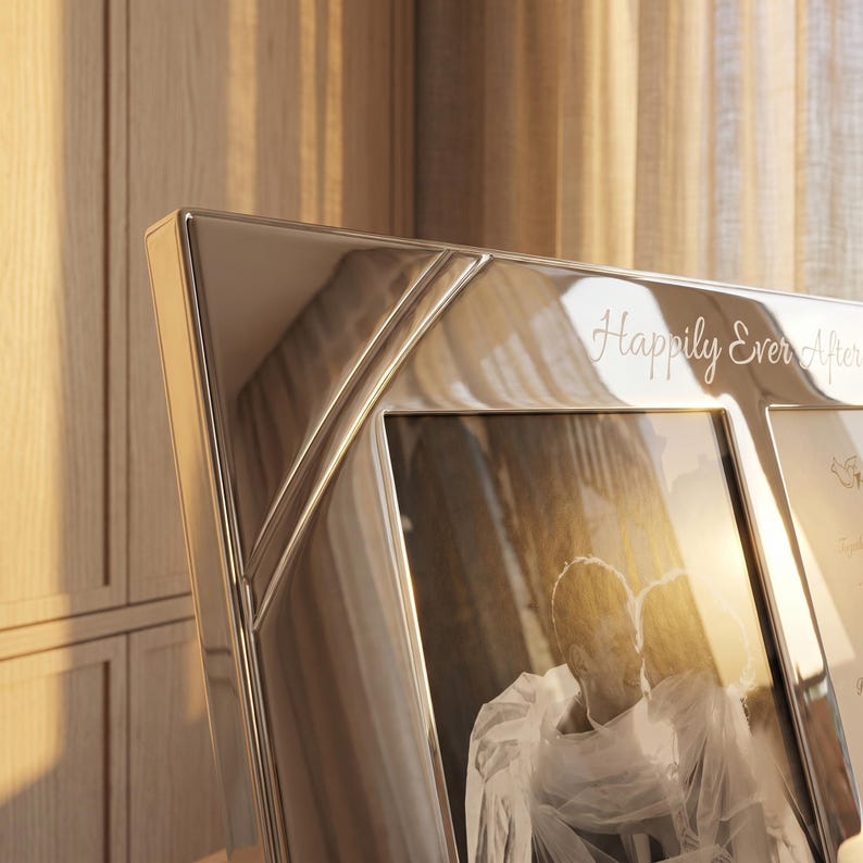 May include: A polished silver-toned metal picture frame with a multi-pane design. The top border features the engraved text "Happily Ever After" in a cursive script. The frame holds a black and white photograph of two people embracing.