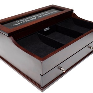 May include: A dark brown wooden watch box with a clear top and two drawers. The top has the text "If perfect's what you see, Then I'd be what you mean to me." The interior is lined with black felt.