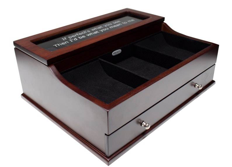 May include: A dark brown wooden watch box with a clear top and two drawers. The top has the text "If perfect's what you see, Then I'd be what you mean to me." The interior is lined with black felt.
