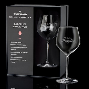 May include: A set of two Waterford Elegance Collection Cabernet Sauvignon wine glasses with the text "Mr. & Mrs. Frangelico" etched on the front of each glass. The glasses are in a black box with the Waterford logo and the text "Cabernet Sauvignon" on the front.