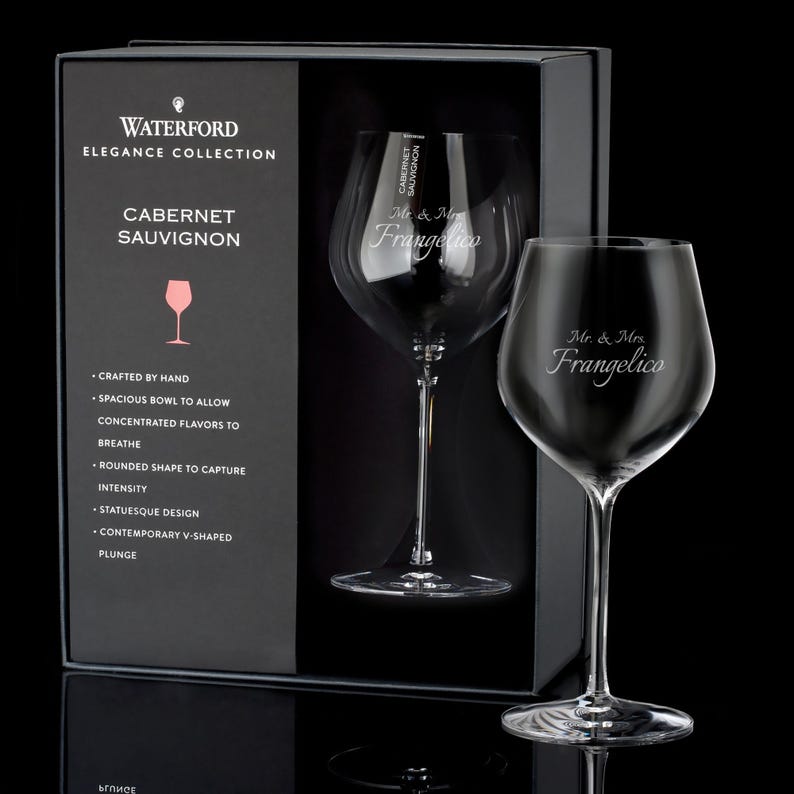 May include: A set of two Waterford Elegance Collection Cabernet Sauvignon wine glasses with the text "Mr. & Mrs. Frangelico" etched on the front of each glass. The glasses are in a black box with the Waterford logo and the text "Cabernet Sauvignon" on the front.