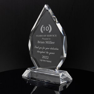Puede incluir: Un premio de cristal transparente en forma de diamante con un borde biselado. El premio tiene el texto "(10) A&Ntilde;OS DE SERVICIO Presentado a Brian Miller Gracias por su dedicaci&oacute;n a lo largo de los a&ntilde;os 2022 Logotipo aqu&iacute; si lo desea" grabado en &eacute;l.