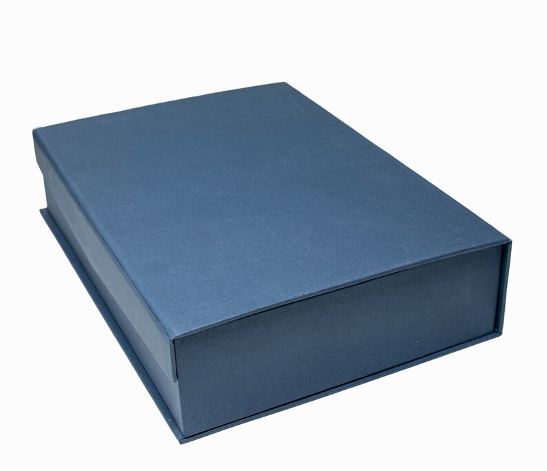 May include: A dark blue rectangular box with a smooth, textured surface. The box is closed and has a slightly rounded edge.