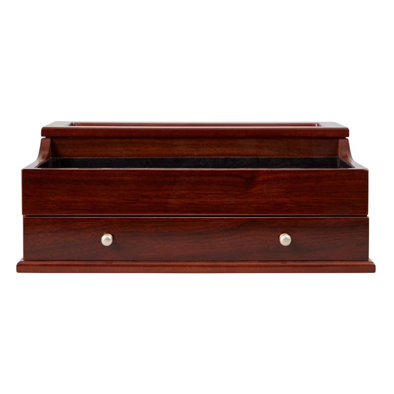 May include: A wooden jewelry box with a rich, dark cherry finish. The box features a drawer with a silver knob and an open top compartment. The interior is lined with a dark fabric. The box is designed for storing jewelry.
