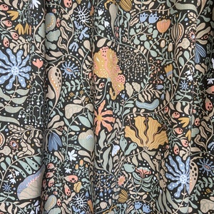 May include: A dark green fabric with a repeating pattern of stylized flowers, leaves, and other organic shapes in shades of pink, blue, and yellow.