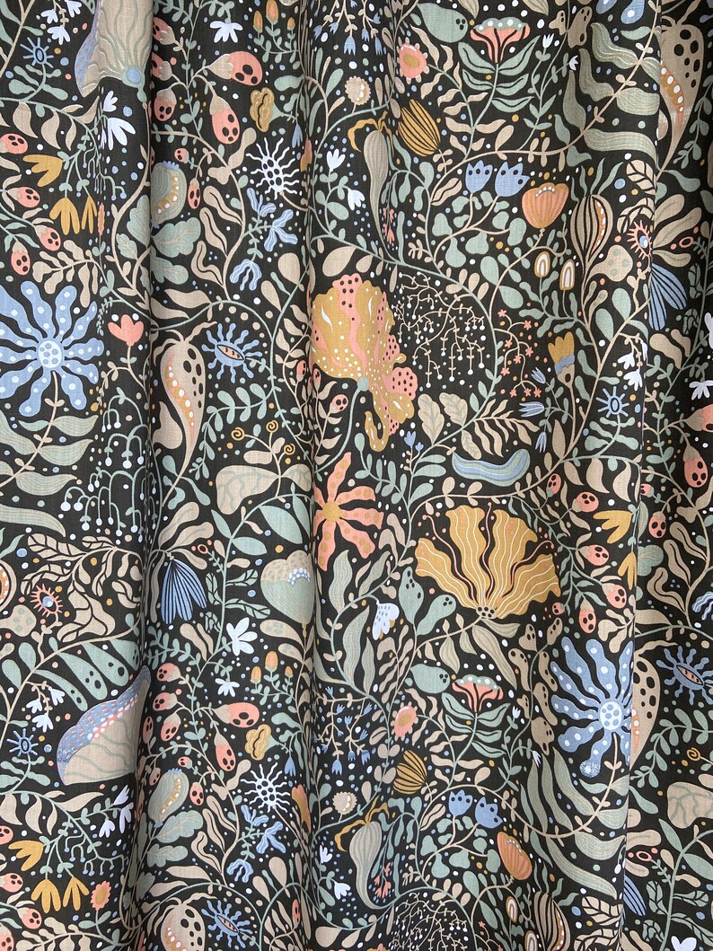 May include: A dark green fabric with a repeating pattern of stylized flowers, leaves, and other organic shapes in shades of pink, blue, and yellow.