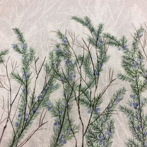 Peut inclure: Un tissu avec un motif aquarelle représentant des branches de pin vertes avec des baies bleues et des tiges marron sur un fond gris clair. Le haut du tissu présente un motif de branches d'arbres blanches.