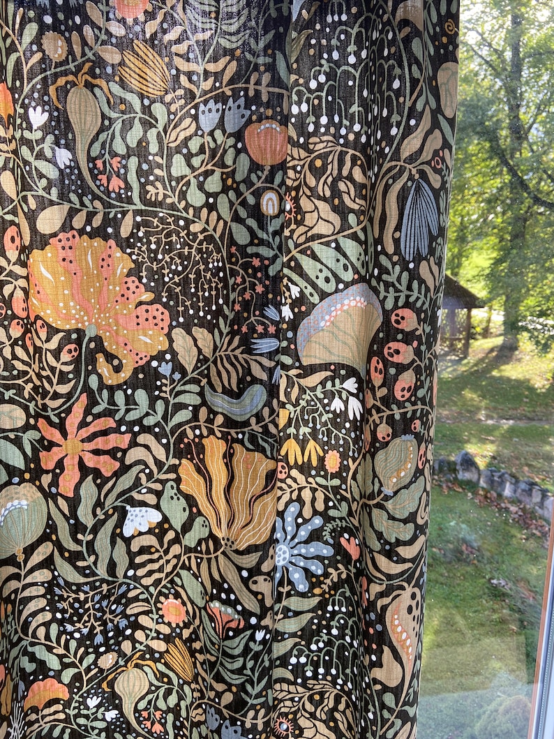 May include: Black fabric with a floral pattern in shades of orange, yellow, green, and blue. The fabric has a textured, linen-like appearance.