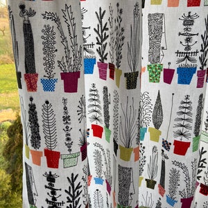 K&ouml;nnte beinhalten: Wei&szlig;er Stoff mit einem sich wiederholenden Muster aus schwarzen Linienzeichnungen von Pflanzen in bunten T&ouml;pfen. Die Pflanzen sind stilisiert und abstrakt, einige &auml;hneln B&auml;umen, Blumen und Farnen. Die T&ouml;pfe sind in verschiedenen Farben, darunter Rot, Gr&uuml;n, Blau und Gelb.
