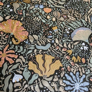 May include: A black fabric with a floral pattern. The flowers are in shades of pink, blue, yellow, and green. The background is a dark black.