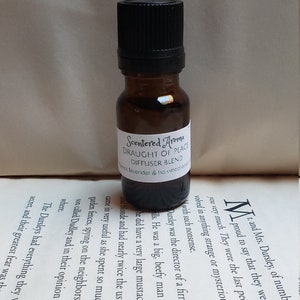 May include: A small brown glass bottle with a black cap. The bottle is labelled "Scentered Aroma Draught of Peace Diffuser Blend Lavender & ho wood essence".