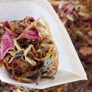 May include: A white paper pouch filled with dried flower petals and herbs, including lavender, rose petals, and calendula. The pouch is open, revealing the contents.