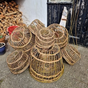 May include: A collection of woven wicker baskets in various sizes and shapes. The baskets are made of natural materials and have a rustic, handmade look.