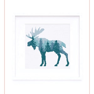 May include: A cross stitch pattern featuring a blue and green moose silhouette with a forest scene inside. The pattern is framed in a white frame and the text "Hipster Stitch Inc." is below the image.