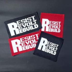 May include: Four black and red fabric patches with white text. The text on each patch reads "Resist Revolt Rebuild".