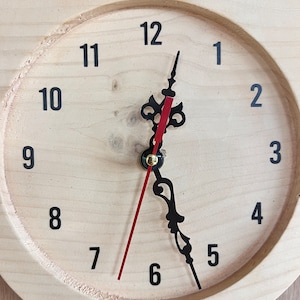 Puede incluir: Un reloj de madera con forma de b&uacute;ho con n&uacute;meros y manecillas negros. La esfera del reloj es de color marr&oacute;n claro con una manecilla de hora roja y una manecilla de minutos negra. Los ojos del b&uacute;ho son amarillos y el pico es naranja.