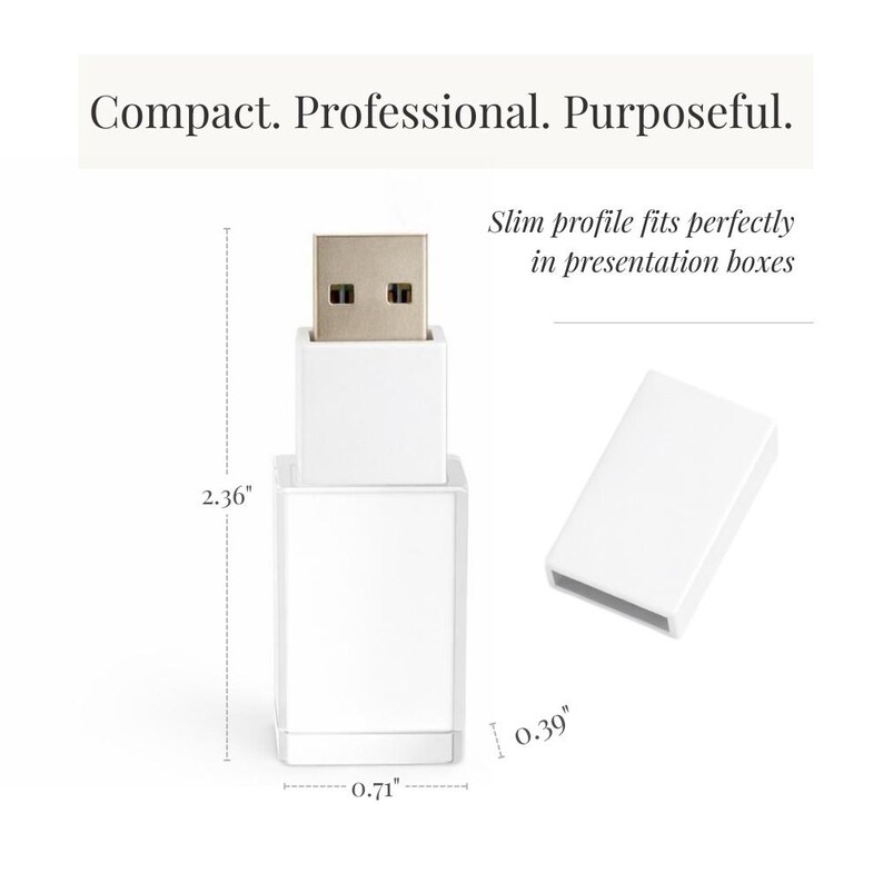 K&ouml;nnte beinhalten: Ein wei&szlig;er USB-Stick mit abnehmbarer Kappe und Metallanschluss. Der Text lautet: Compact. Professional. Purposeful. Slim profile fits perfectly in presentation boxes. Die Ma&szlig;e betragen 5,99 cm in der H&ouml;he, 1,80 cm in der Breite und 0,99 cm in der Tiefe.