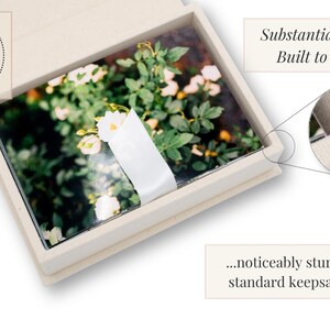 May include: A rectangular off-white keepsake box containing a stack of photographs featuring white flowers and green foliage, secured with a white paper band. Text on the image reads: Assembled & quality-checked in-house, Substantial. Solid. Built to Last... ...noticeably sturdier than standard keepsake boxes.