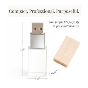 May include: A silver and white USB flash drive with a detached light wood cap. Text reads: Compact. Professional. Purposeful. Slim profile fits perfectly in presentation boxes. Dimensions are 2.36 inches in height, 0.71 inches in width, and 0.39 inches in depth.
