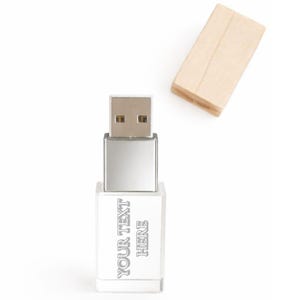 May include: A silver-colored USB flash drive with a rectangular body featuring the engraved text "YOUR TEXT HERE" on the front surface. The device includes a metallic USB connector and a separate, detached light-colored wooden cap.