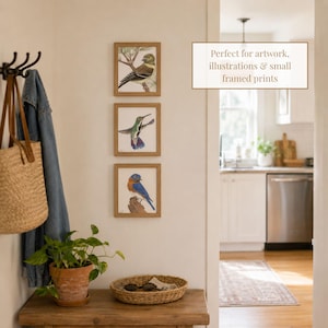 May include: Three square wooden frames containing bird illustrations are mounted vertically on a wall. The top frame shows a goldfinch, the middle a hummingbird, and the bottom a bluebird. Text on the wall reads: Perfect for artwork, illustrations & small framed prints.