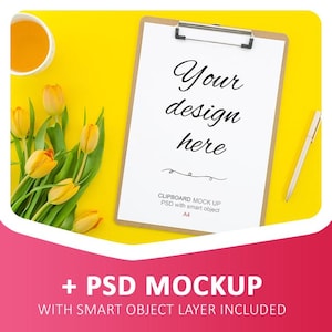May include: A brown clipboard with a white sheet of paper on a yellow background. The paper has the text "Your design here" written on it. There is a pen and a bouquet of yellow tulips in the image.