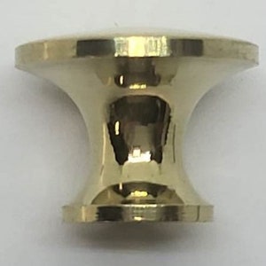 May include: A polished brass cabinet knob with a round top and a flared base.