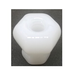 May include: White ceramic knob with a hexagonal shape and a smooth, glossy finish. The knob has a central hole for mounting.
