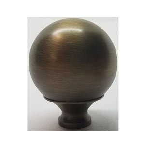 May include: A round, antique brass finial with a smooth, slightly textured surface. The finial has a small, round base.