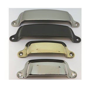May include: Four cabinet pulls in different finishes: nickel, black, brass, and polished chrome. Each pull has a curved, slightly rounded shape.
