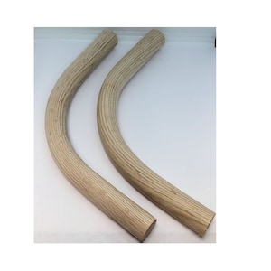 May include: Two curved wooden pieces, likely for furniture construction. The wood has a light, natural color with visible grain. Each piece is approximately 1 inch in diameter and curves gently. The ends are cut flat, suggesting they are ready for assembly.