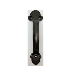 May include: Black cast iron door handle with a decorative design. The handle has a curved shape and two small holes on each end.