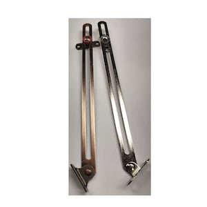 May include: Two silver-toned metal cabinet door stay supports. The supports are extended and have a spring-loaded hinge.