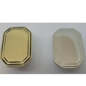 May include: Two octagonal-shaped cabinet knobs, one in polished brass and one in polished nickel.