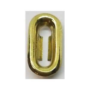 May include: A gold-colored metal oval ring with a keyhole-shaped opening in the center.